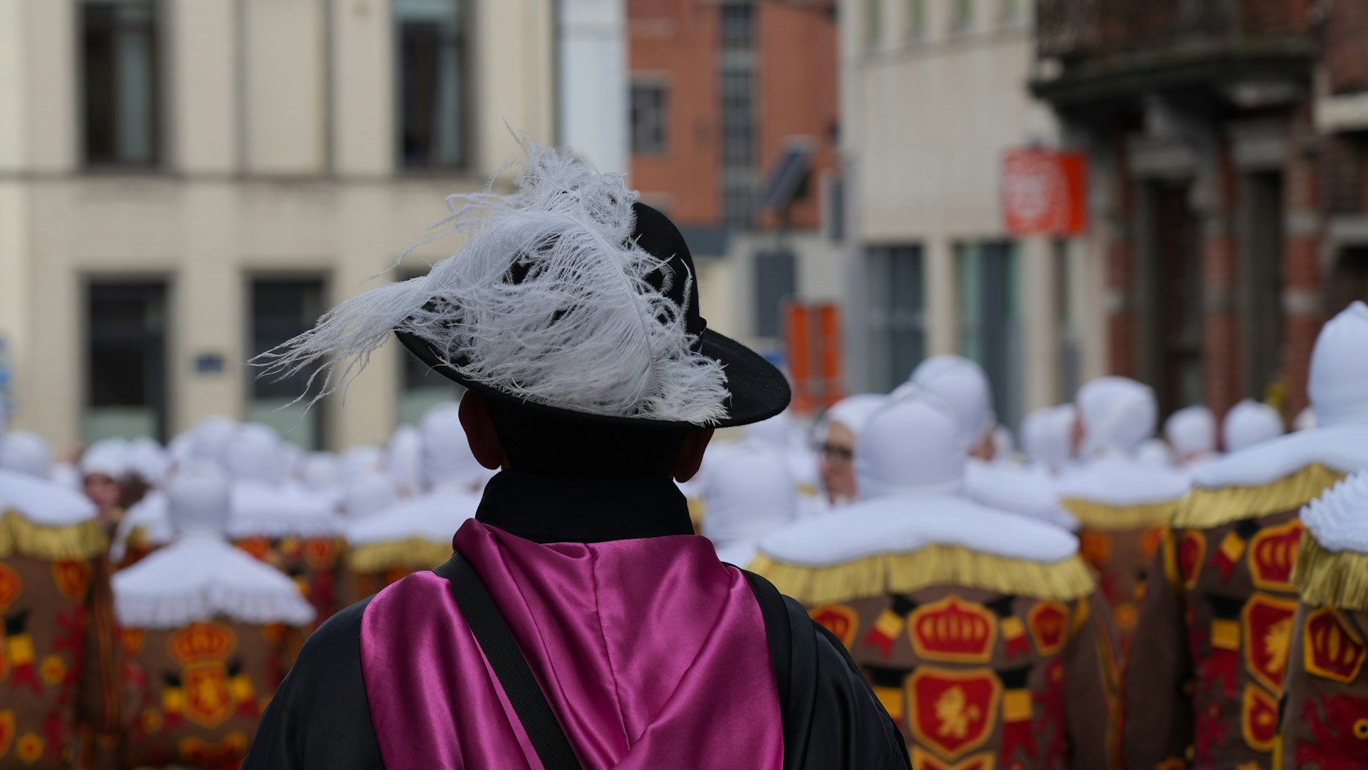 a man in a black hat and a purple cape